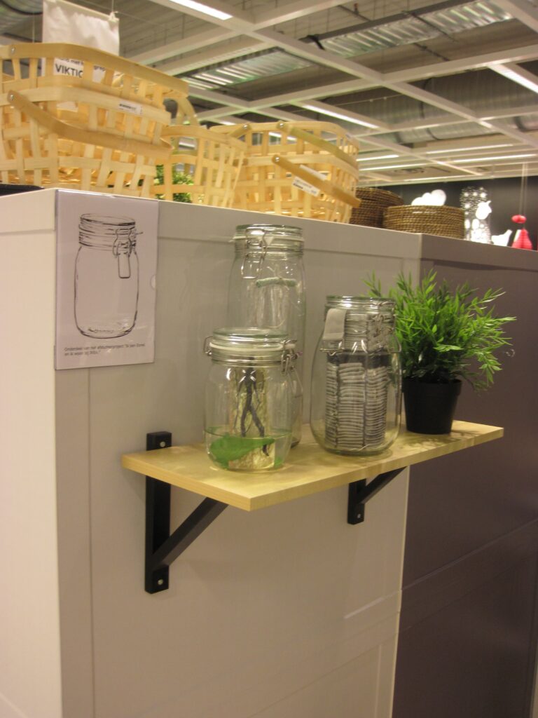 Three jars placed on the IKEA;s store’s floor plan, each holding traces of Esmé’s silent interventions